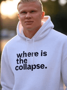 a man wearing a white hoodie that says " where is the collapse "