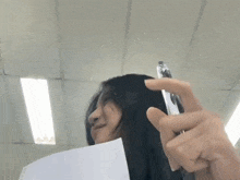 a woman with long hair is holding a piece of paper