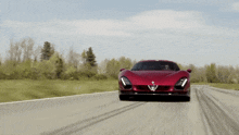 a red alfa romeo sports car is driving down the road