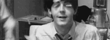 a black and white photo of a man wearing a tie and a shirt .