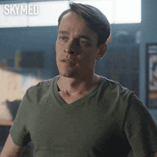 a man in a green t-shirt with skymed written on the bottom