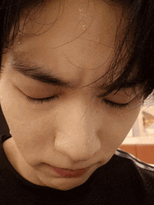 a close up of a person 's face with sweat coming out of their forehead