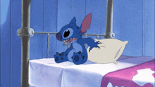 a cartoon character named stitch is sitting on a bed with a pillow