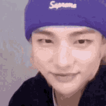 a close up of a person wearing a purple beanie and smiling .