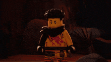 a lego figure with a scarf around his neck has a dragon tattoo on his chest