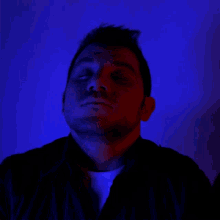 a man with his eyes closed and a blue background
