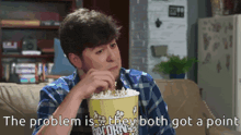 a man sitting on a couch eating popcorn with the words the problem is they both got a point