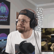 a man wearing headphones looks at a screen with a chicken dinner poster behind him