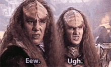 two aliens with long hair are standing next to each other and one of them is saying eew and the other is saying ugh .
