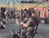 a man holding a camera in front of a crowd of people