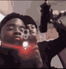 a man is holding a gun in front of his face while taking a selfie .