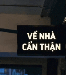 a black sign that says ve nha can than in white letters