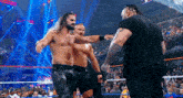 a group of men are standing in a wrestling ring and talking to each other .