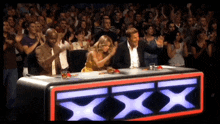 a group of people sitting at a table with a xxx sign on it