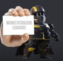a hand holding up a card that says meme stealing licence