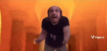 a man with a beard is standing in front of a fire in a room .