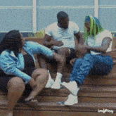 a group of people are sitting on a set of wooden stairs with the words imgplay written on the bottom
