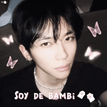 a young man is wearing a black shirt and a pearl necklace with the words soy de bambi written above him