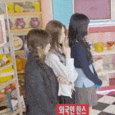 three girls are standing in a store with a sign that says chocowrap