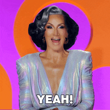 a woman in a silver dress says yeah on a purple background