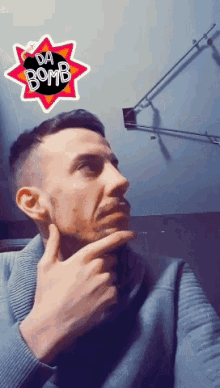 a man has a sticker on his face that says " da bomb "