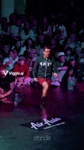 a man wearing a sweatshirt that says stance on it is dancing in front of a crowd