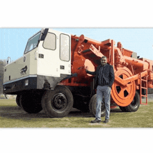 a man stands in front of a large truck that says rr on it