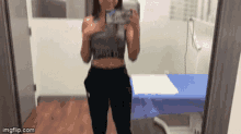a woman taking a picture of herself in a mirror with imgflip.com