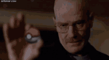 a man is holding a pokemon ball in his hand .