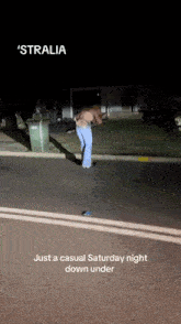 a woman is standing on the side of the road at night with the caption ' stralia just a casual saturday night down under
