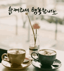 two cups of coffee sit on a saucer on a table with a vase of flowers in the background