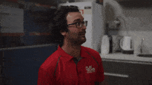 a man wearing glasses and a play tech shirt