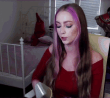 a woman with long purple hair is singing into a microphone