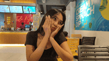 a woman sitting at a table in front of a wall that says cream spinach dip