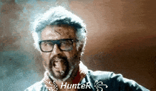 a man with glasses and a beard is making a funny face and says hunter .