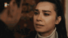 a man and a woman are looking at each other and the woman is crying