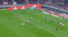 two soccer players are hugging each other on a field with a score of 1 to 1