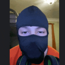 a man wearing a black mask and headphones looks at the camera