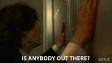 a man in a suit is leaning against a wall and asking if there is anybody out there .