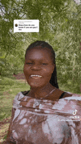 a woman with braces on her teeth is smiling in front of trees