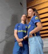 two women wearing blue shirts with herbalife on them