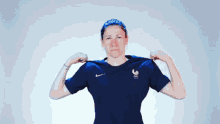 a woman wearing a blue nike shirt with a rooster on the front