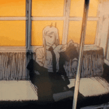 a man in a suit and tie is sitting on a train looking out a window