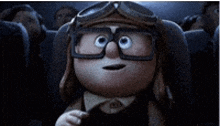 a cartoon character wearing goggles and glasses is sitting in a movie theater .
