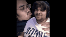 a man wearing a shirt that says ' jordan ' on it kisses another man on the cheek