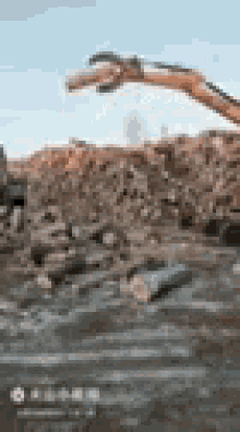 a bulldozer is moving a pile of rocks in a pile of trash .