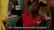a man in a red shirt is sitting on a couch and says `` but i already did something today ! ''