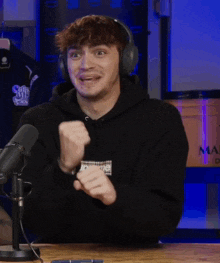 a man wearing headphones and a black supreme sweatshirt