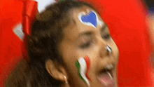 a girl with a heart painted on her face .