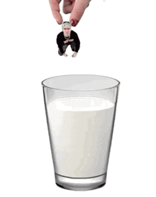 a hand is reaching into a glass of milk with a picture of a man in a black shirt on it